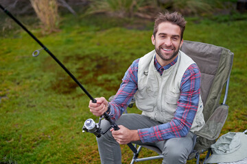 Happy, man and fishing in natural water lake for vacation, camping and sports in nature for adventure. Fisherman, environment and energy in morning for health, wellness and breakfast in outdoor camp