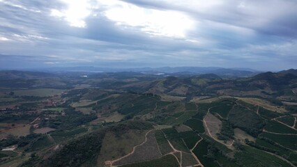 Aerial shot of mountains with green coverages and a skyline