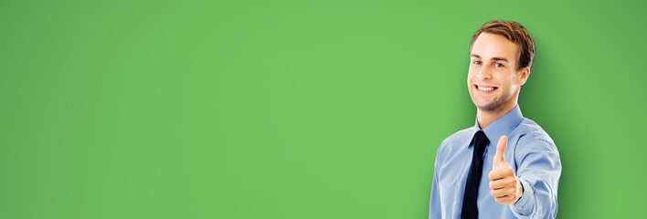 Portrait image - smiling confident businessman business man show thumbs up like hand sign gesture, isolated against green chroma key background. Happy confident man gesturing. Free ad text area.