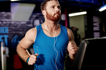 Earphones, exercise and man running on treadmill in gym for health, wellness and body weightloss. Fitness, runner and male athlete with cardio workout on machine for race training in sports center. - obrazy, fototapety, plakaty