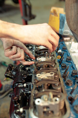 Vertical closeup shot of a mechanic mounting the car engine