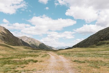 Landscape shot of a grass field with a mountain in the background on a sunny day