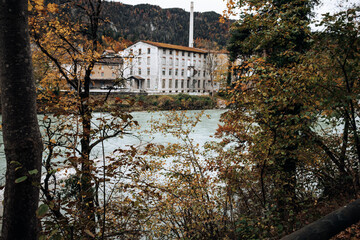 Autumnal Alpine Industry: A White Factory Beside the Riverside