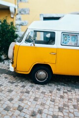 Vintage van parked on a street in front oa a yellow house