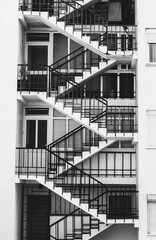 Vertical greyscale shot of a modern building with straight stairs