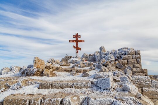 View of Orthodox cross on Rtanj mountain summit in winter, Serbian Carpathians