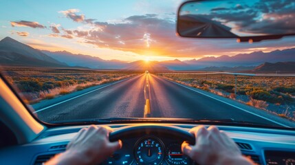 Driver's perspective on an open road journey towards a stunning sunset with mountain views.