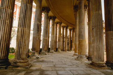 Ancient colonnade, with the rhythmic alignment of weathered columns adorned with intricate designs.