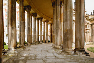 Ancient colonnade, with the rhythmic alignment of weathered columns adorned with intricate designs.