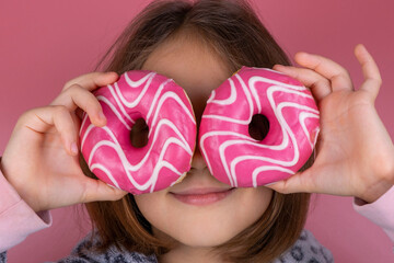 girl in kigurumi or pajamas with donuts in place of the eyes on a pink background