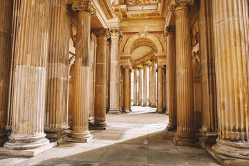 An elegant corridor adorned with intricately designed columns and arches, bathed in soft light and...