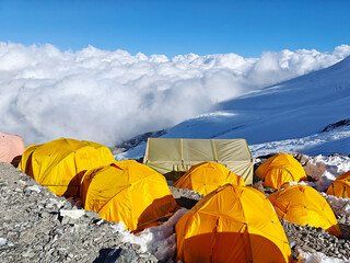 Himalayan mountain camp in Nepal, colorful tents, glacier, and clouds