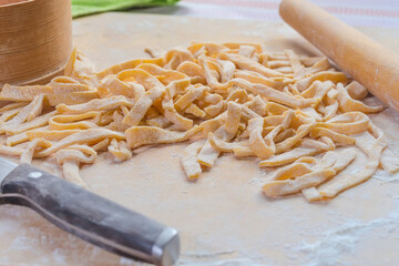 Fresh raw homemade egg noodles on wooden board, close-up - 781234603