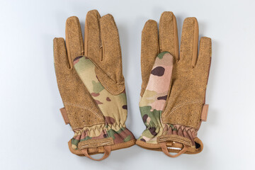 Green-brown tactical military gloves on a gray background - 781234620