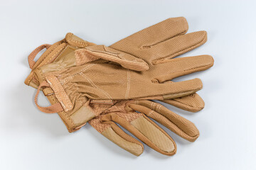 Beige tactical military gloves on a gray background - 781234628