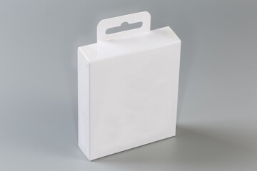 White rectangular cardboard hang tab packing box on gray surface