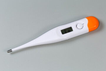Electronic medical thermometer ready to use on a gray surface - 781234667