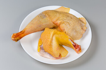 Raw chicken leg and shoulder on dish on gray background - 781234674