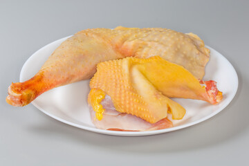 Raw chicken pieces on dish on gray background, side view - 781234678