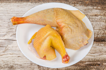 Raw chicken pieces on dish on old cracked wooden plank © An-T