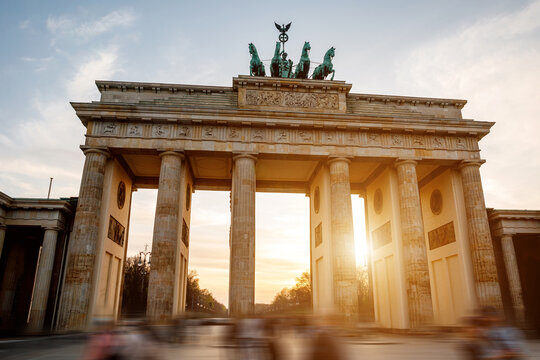 The iconic Brandenburg Gate in Berlin against the backdrop of a soft sunset sky