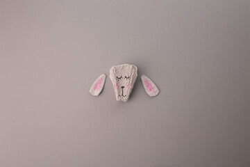 a close up of a crafted head animal on a grey surface, part of making process, made from paper egg...