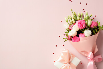 Bouquet of flowers and gift box on pink background with confetti. Happy Mother's Day, International Womens day, birthday concept.