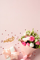Happy mother's day composition with gift box and bouquet of flowers on pink background. Flat lay, top view, vertical.