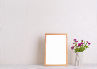 Chrysanthemum flowers and frame  mockup over white wall.