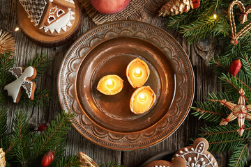 Candles made of bees wax and nut shells floating in a bowl of water at Christmas, top view