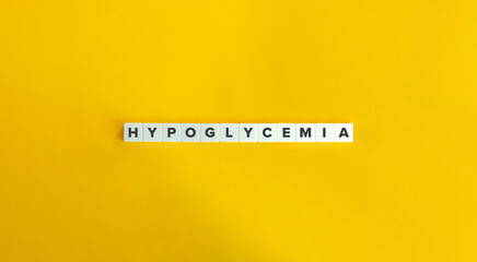 Hypoglycemia Word. Low Blood Sugar Concept. Text on Block Letter Tiles on Yellow Background....