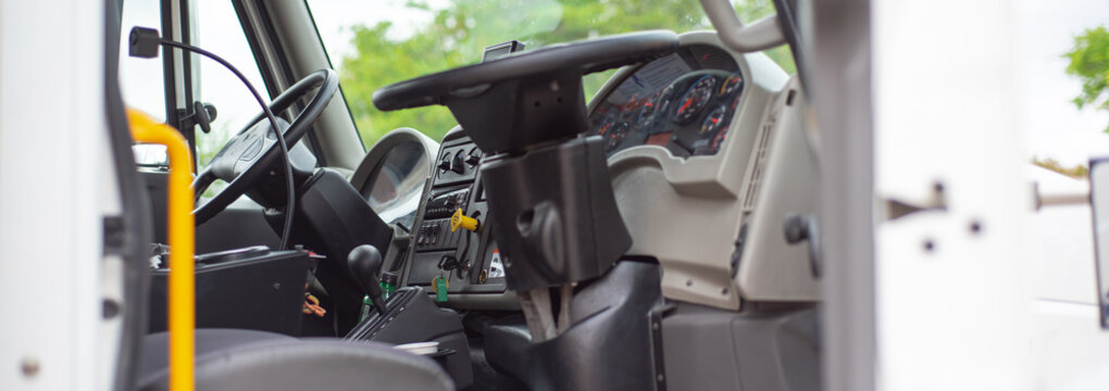 Panorama view two steering wheels for dual control on modern four wheel mechanical broom sweeper truck, cabin complete with fully dualized operate from closest street curb side optimize sweeping