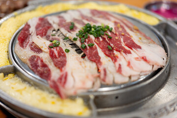 Korean barbecue restaurant, the waiter lays a barbecue net on the red environmentally friendly...