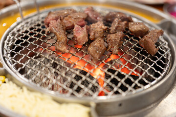 Korean barbecue restaurant, the waiter lays a barbecue net on the red environmentally friendly...