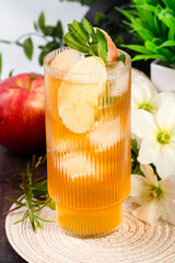 Glass of apple cider surrounded by flowers