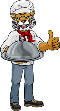 A wildcat chef mascot cartoon character holding a silver platter cloche dome of food and giving a thumbs up