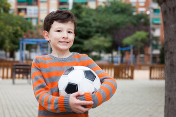 Boy holding soccer ball outdoors