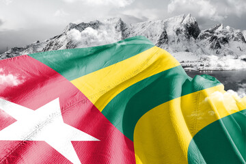 Togo national flag cloth fabric waving on beautiful ice Mountain Background.