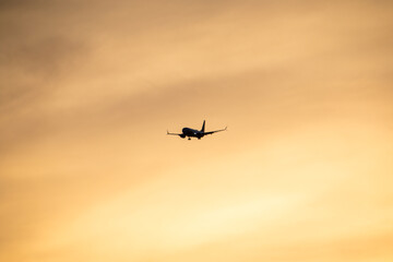 Airplane flying in the sky at sunset