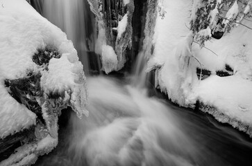 Mountain river in winter with flowing water and snow