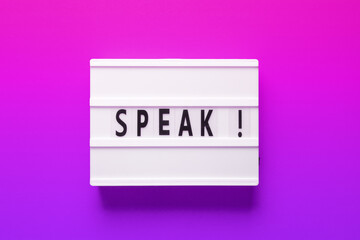 A rectangular light box featuring the word speak in a vibrant font, set against a background blending shades of purple, pink, and electric blue. Perfect for branding and graphic design purposes