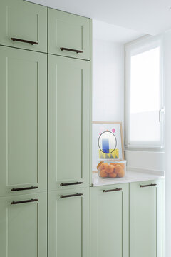 Pastel green kitchen cabinets in minimalist interior