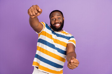 Photo of impressed funky man wear striped t-shirt driving automobile isolated violet color background - obrazy, fototapety, plakaty