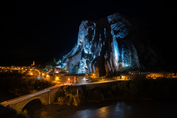 The Rocher de la Baume rock formation in the town of Sisteron, France, lit up at night.