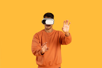 Man in VR headset gesturing on orange background