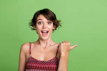 Photo of charming lovely glad girl wear stylish clothes presents poster empty space isolated on...