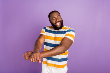 Photo of funky cheerful man wear striped t-shirt having fun empty space isolated violet color...