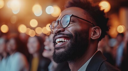 Happy bearded man with glasses smiling at the camera in front of a group of people