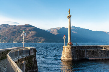 The old port with the statue of Madonnina in Luino, located on the coast of Lake Maggiore, Italy