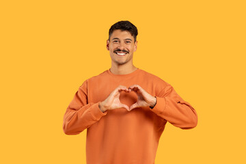Man with moustache making heart shape with hands - obrazy, fototapety, plakaty